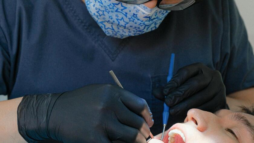Dental hygienist performing preventive cleaning for patient with dental restorations