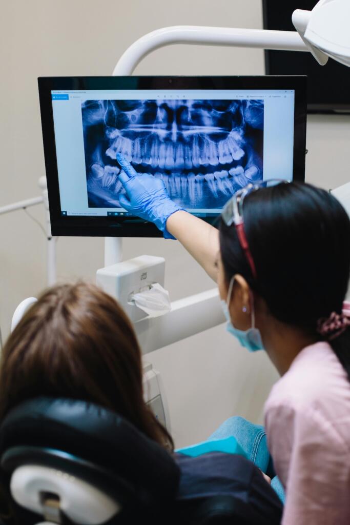 Dentist and patient discussing a treatment plan looking at a dental X-ray