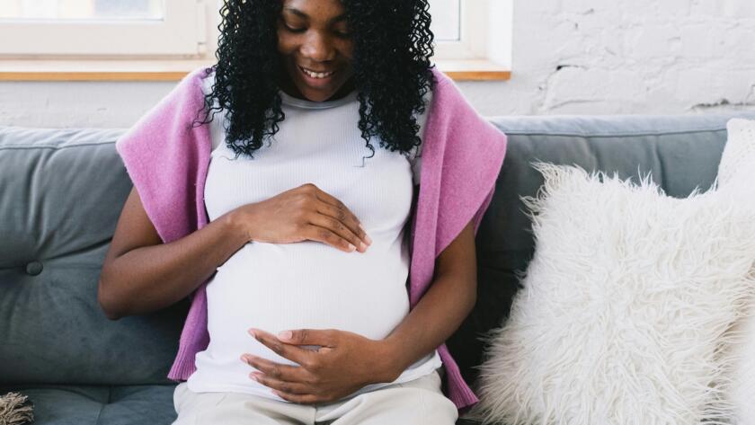 Pregnant woman resting her hands on her belly during pregnancy